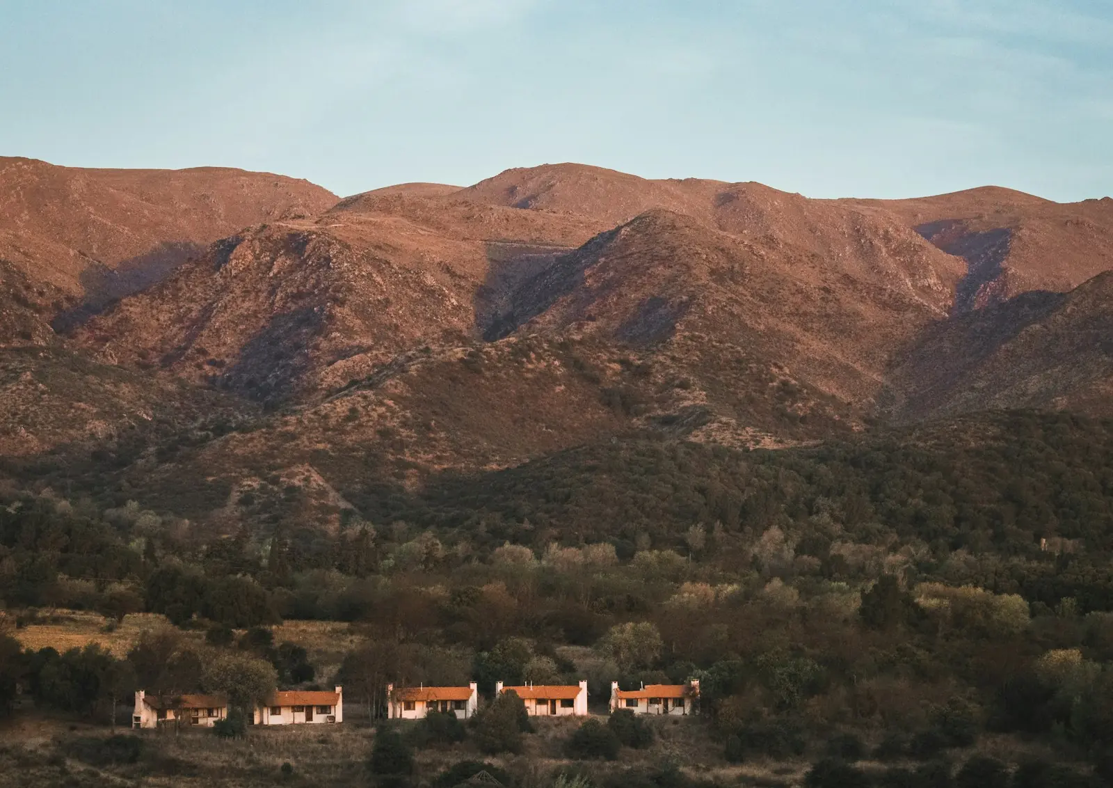 Sierras al atardecer con casas al pie